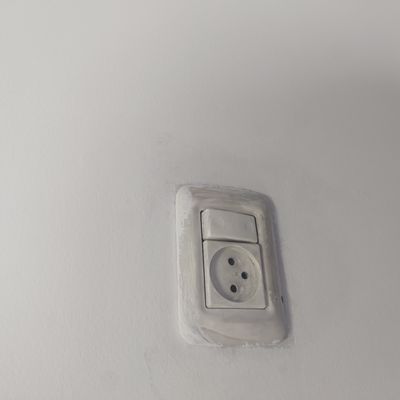 שקע חשמל ומתג על קיר לבן